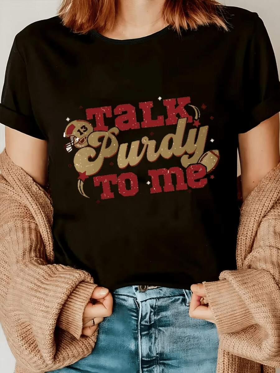 Frase inspirada en la pasión por el fútbol americano con letras grandes en rojo y dorado acompañada de un casco y balón que evocan fuerza diversión y espíritu deportivo camiseta de mujer casual moderna cómoda para amantes del deporte - Negro - Ver 1
