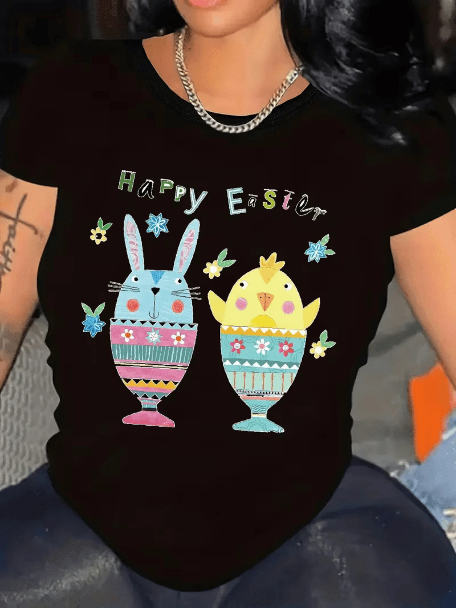 Conejos y pollito dentro de huevos coloridos que simbolizan la alegría y el renacer de la Pascua con flores y tonos vivos que transmiten energía positiva camiseta de mujer casual elegante para días festivos - Negro - Ver 1