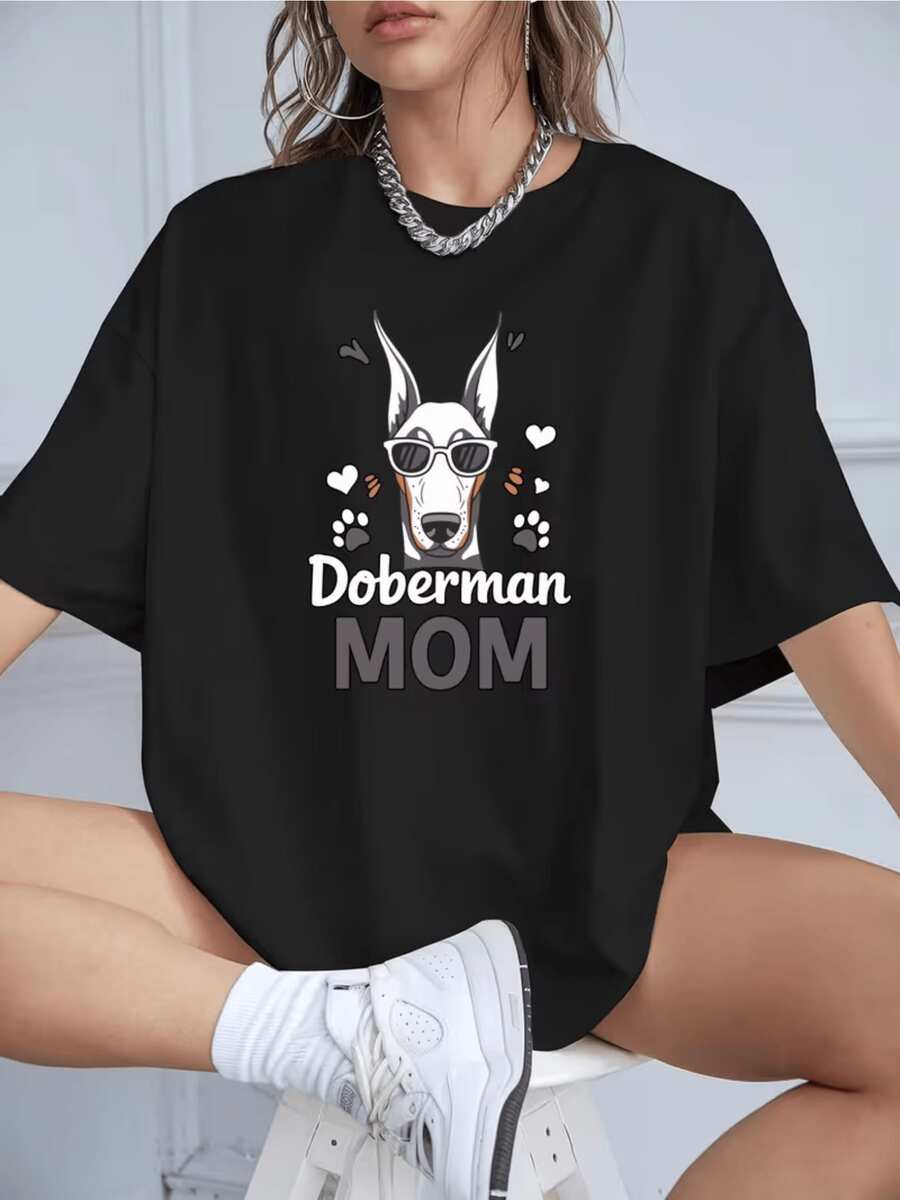 Figura de un dóberman con gafas rodeado de huellas y corazones que simboliza el amor y orgullo de una madre por su mascota camiseta de mujer casual cómoda para uso diario - Negro - Ver 1