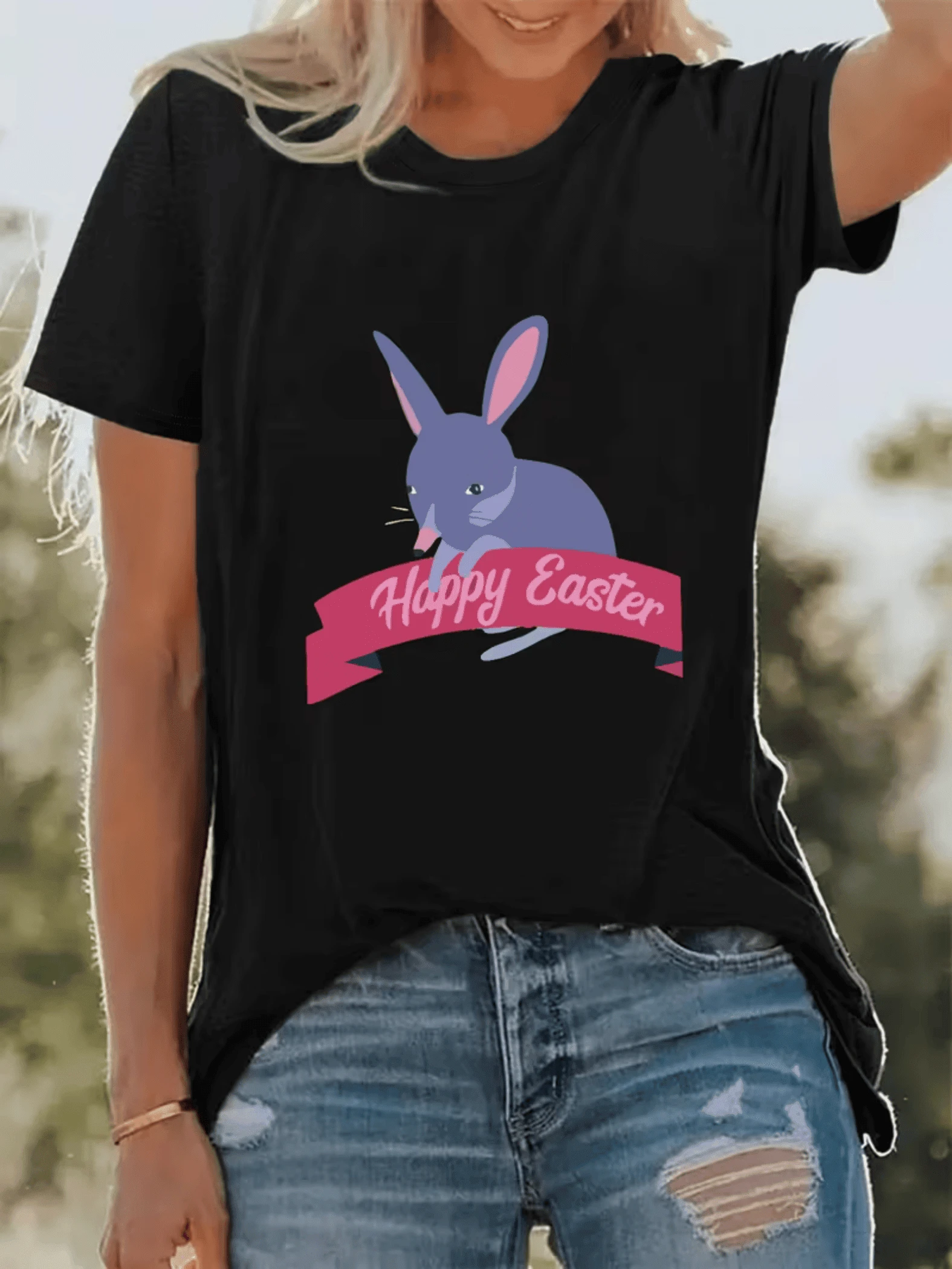 Conejo morado con orejas rosas sostiene una cinta con mensaje festivo simbolizando alegría y esperanza de Pascua en camiseta de mujer casual moderna cómoda y perfecta para días soleados - Negro - Ver 1