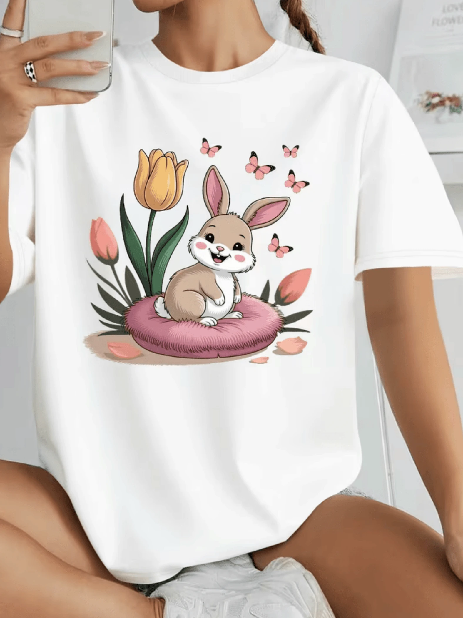 Cheerful Rabbit Sitting On A Soft Pink Cushion Surrounded By Colorful Tulips And Small Butterflies Symbolizing Tenderness, Hope, And Joy. Comfortable And Adorable Casual Women's T-Shirt, Ideal For Everyday Wear. - 白色 - 查看 1