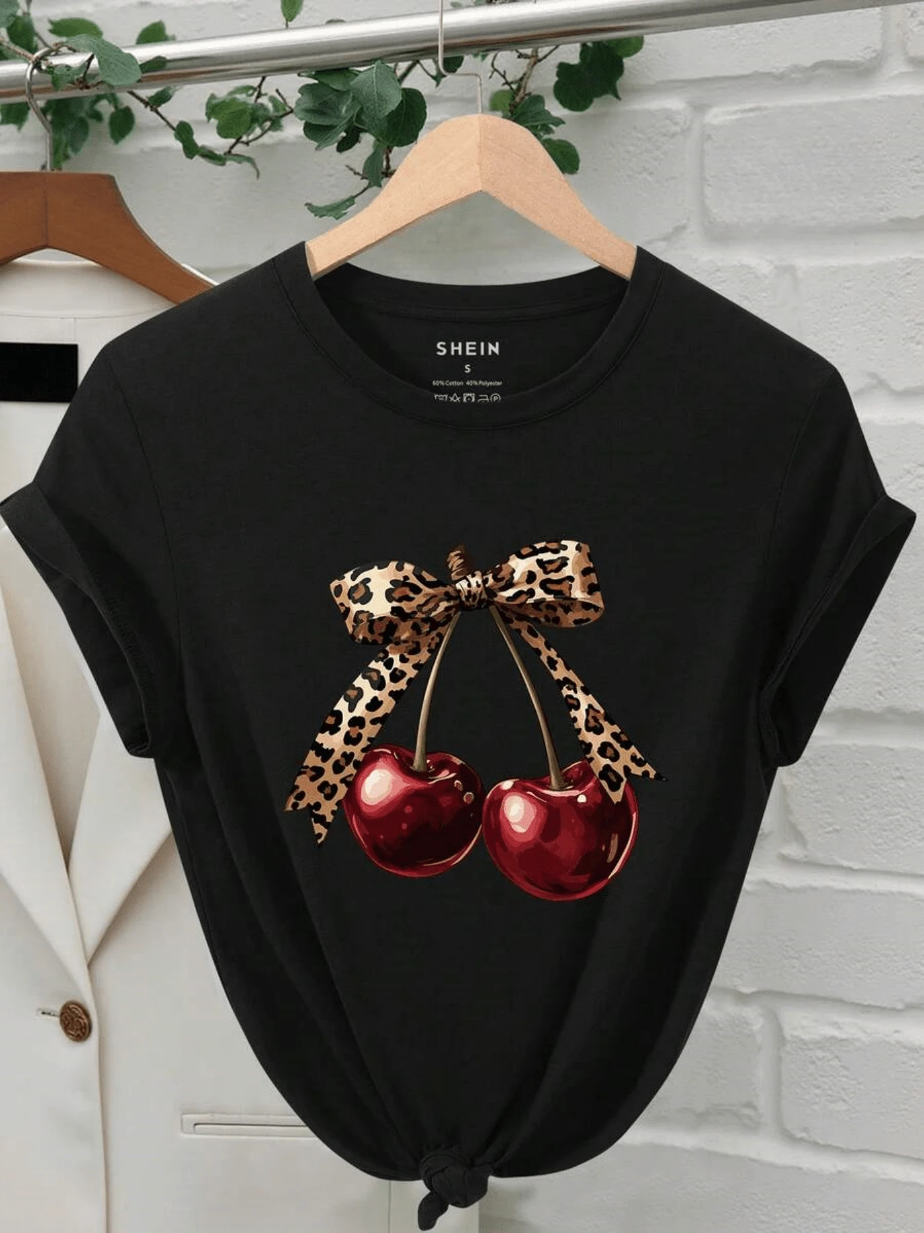 Dos cerezas brillantes unidas por un lazo de estampado felino que simboliza energía y feminidad combinando alegría y estilo moderno camiseta de mujer casual elegante para verano - Negro - Ver 1