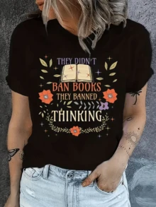Libro abierto rodeado de flores coloridas y hojas verdes simbolizando libertad de pensamiento y poder del conocimiento en época moderna camiseta de mujer casual cómoda ideal para uso diario - Negro - Ver 1