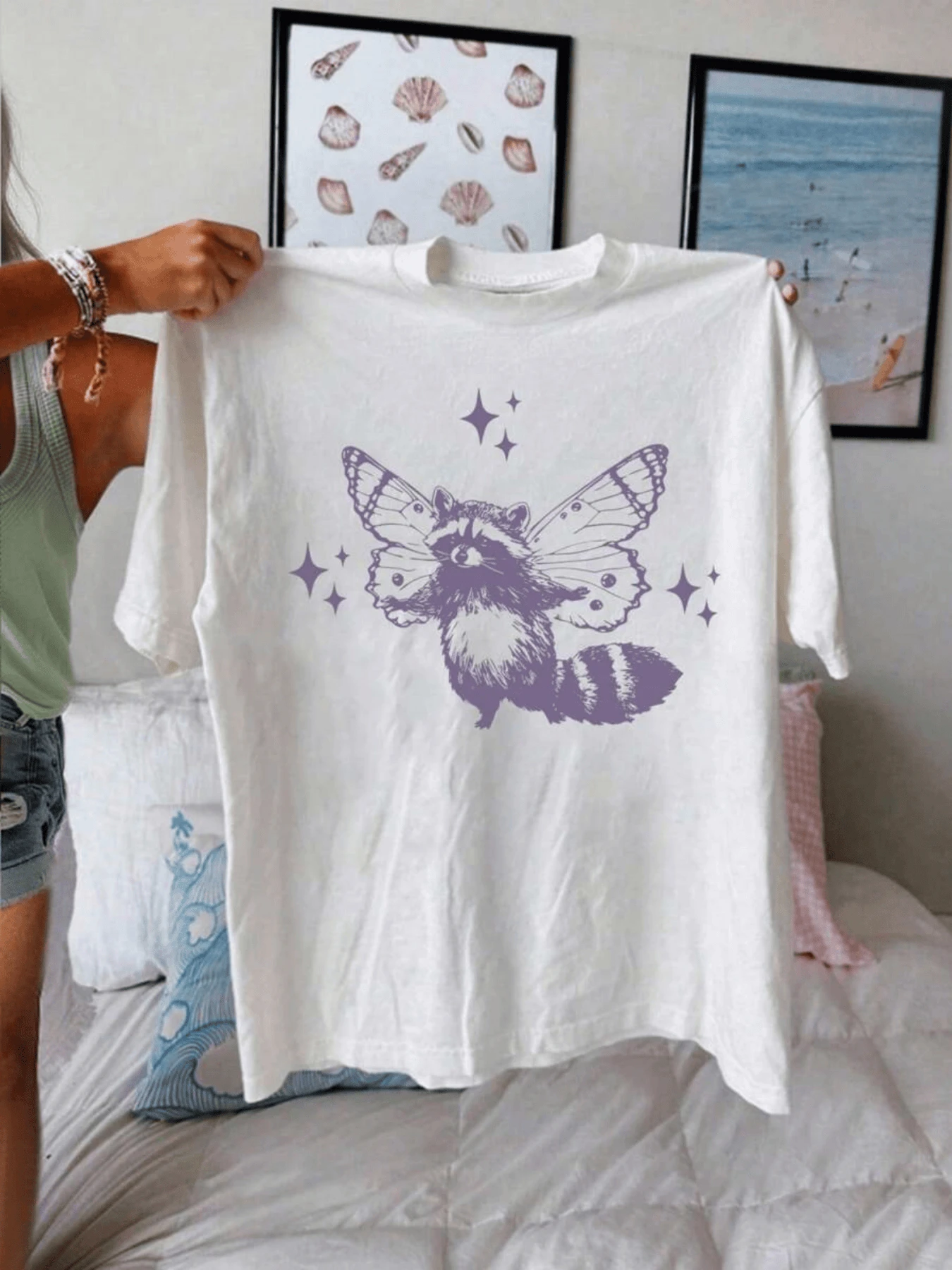 Un mapache con alas de mariposa rodeado de estrellas simboliza la unión entre la naturaleza y la fantasía transmitiendo libertad y magia camiseta de mujer casual cómoda para uso diario - Blanco - Ver 1