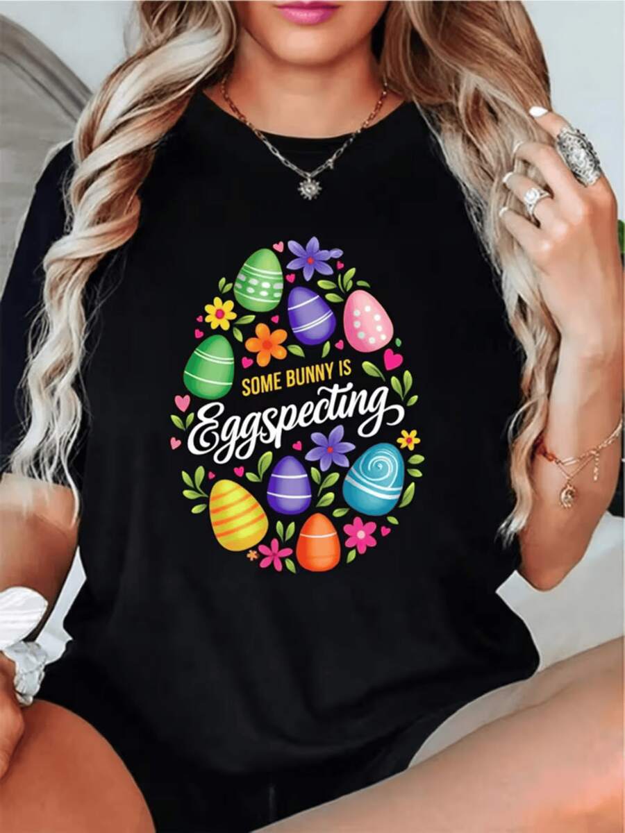 Huevos coloridos rodeados de flores alegres simbolizan la celebración de la vida nueva y la felicidad primaveral con un toque divertido camiseta de mujer para ocasión casual cómoda y moderna - Negro - Ver 1