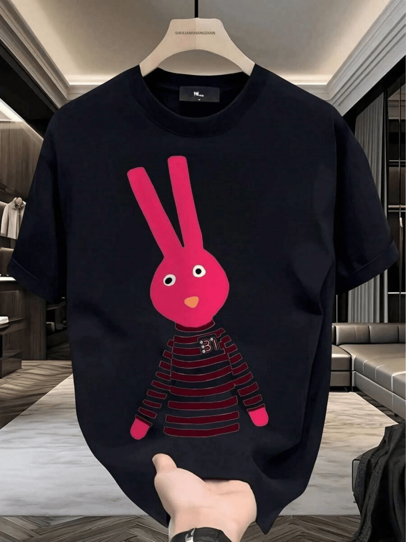 Pink Rabbit Figure With A Playful Expression Representing Youthful Energy And A Positive Attitude, Wearing A Red Striped T-Shirt, A Symbol Of Confidence And Modern Style For Those Seeking To Stand Out With Simplicity. A Modern, Casual, Comfortable Men's T-Shirt For Everyday Wear. - 黑色 - 查看 1