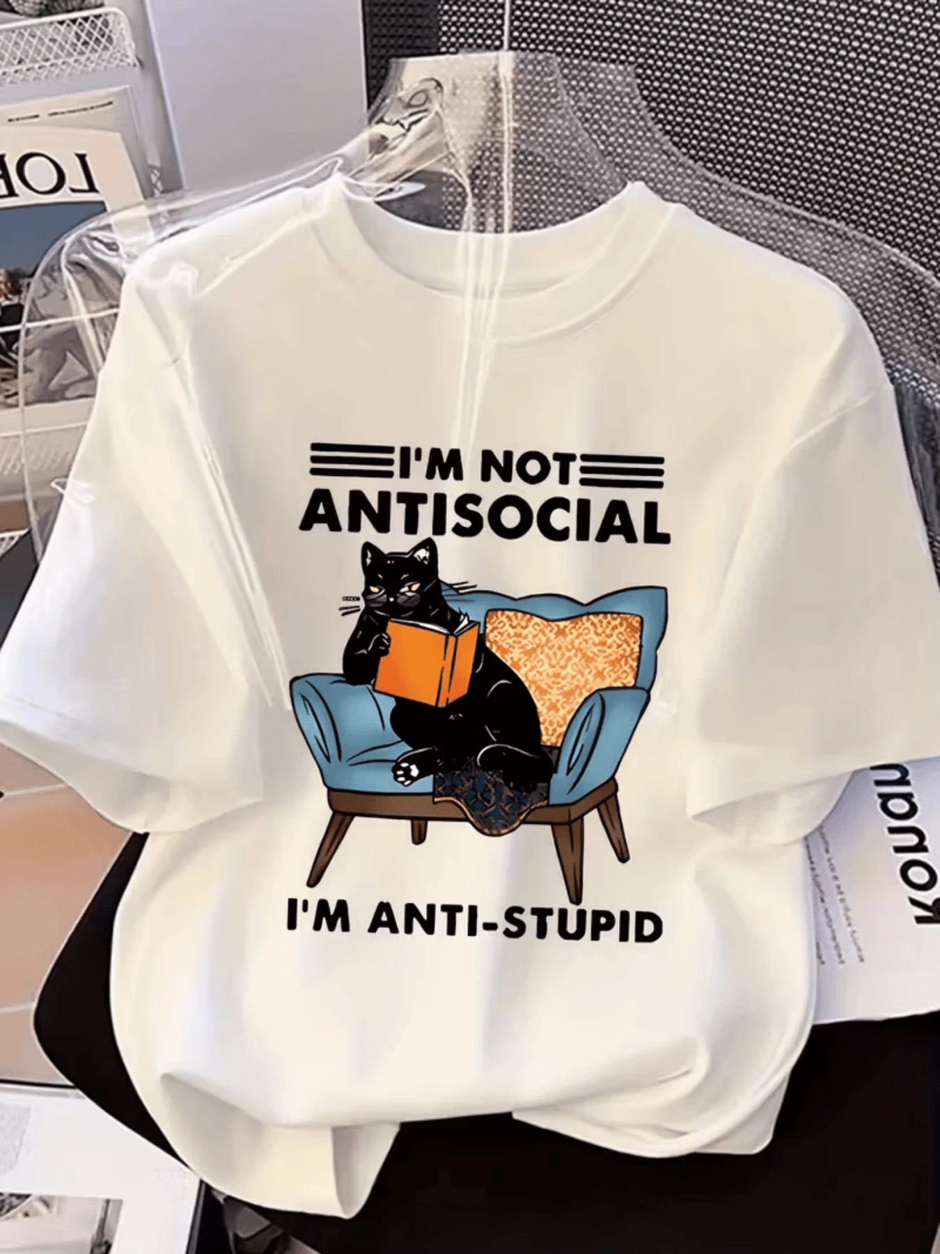 A Black Cat Reading A Book While Sitting In A Blue Armchair Expresses A Fun And Intelligent Attitude With An Ironic Message, Ideal For Women With A Unique Sense Of Humor. A Modern, Casual Women's T-Shirt. - 白色 - 查看 1