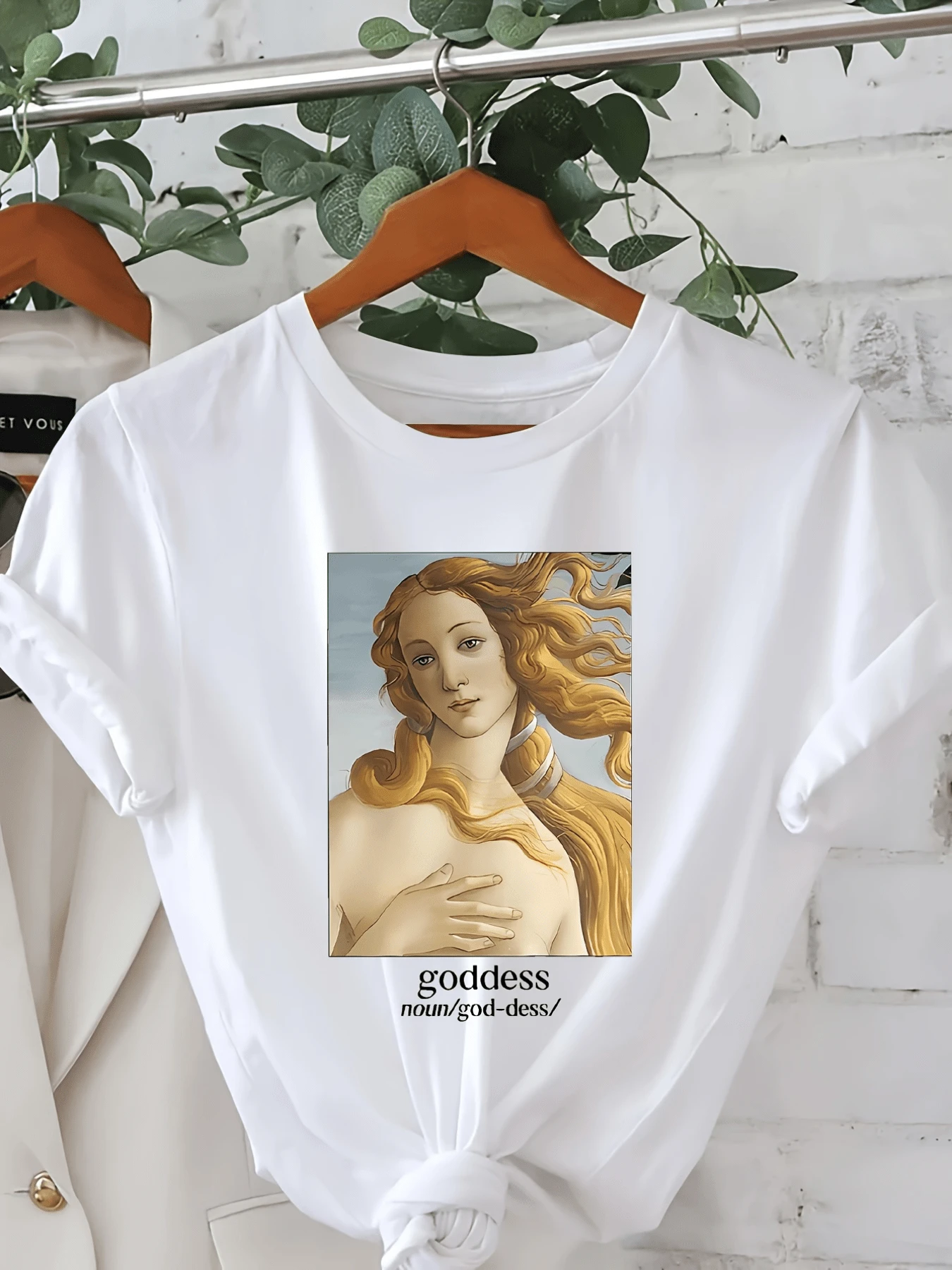 Figura artística de una mujer con cabello dorado al viento que simboliza fuerza belleza y libertad interior inspirando confianza y serenidad camiseta de mujer elegante casual moderna - Blanco - Ver 1