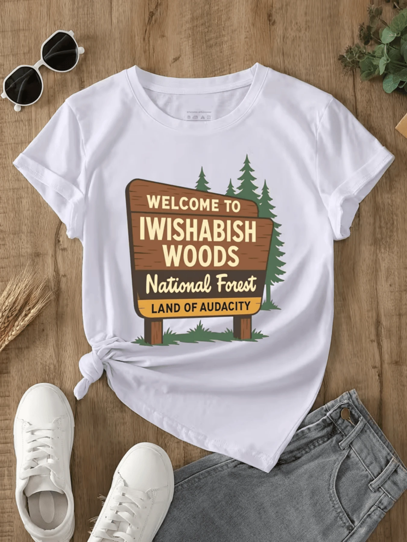 Paisaje de bosque con cartel que da la bienvenida a un lugar imaginario lleno de árboles pinos y espíritu aventurero que inspira libertad y conexión con la naturaleza camiseta de mujer casual cómoda y moderna - Blanco - Ver 1