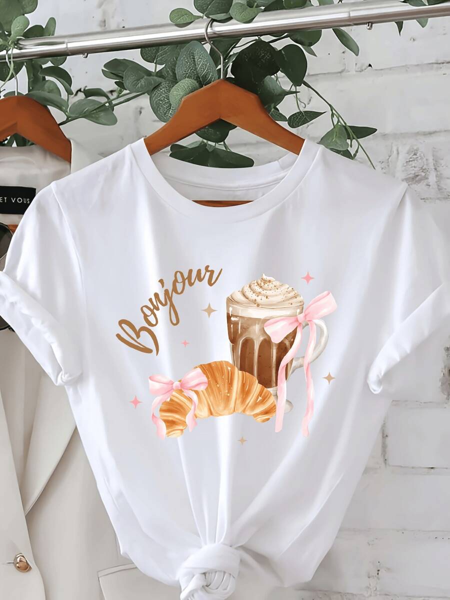Croissant dorado con lazo rosa junto a taza de café con espuma evocando amanecer parisino lleno de encanto francés y energía positiva camiseta de mujer casual cómoda ideal para diario - Blanco - Ver 1
