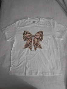 Large Central Bow With Leopard Pattern And Pink Ribbons Symbolizing Elegance, Strength And Femininity In Vibrant Contrast With The White Background. Modern And Comfortable Casual Women's T-Shirt - White - View 8