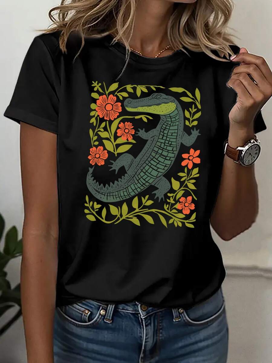 Cocodrilo verde rodeado de flores naranjas que simbolizan fuerza vital y equilibrio natural en conexión con la tierra camisetas de mujer casual moderna cómoda para uso diario - Negro - Ver 1