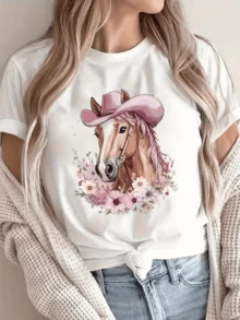 Caballo con sombrero rosa rodeado de flores que representa la fuerza noble y la libertad del espíritu femenino en un entorno natural camiseta de mujer casual y moderna - Blanco - Ver 1
