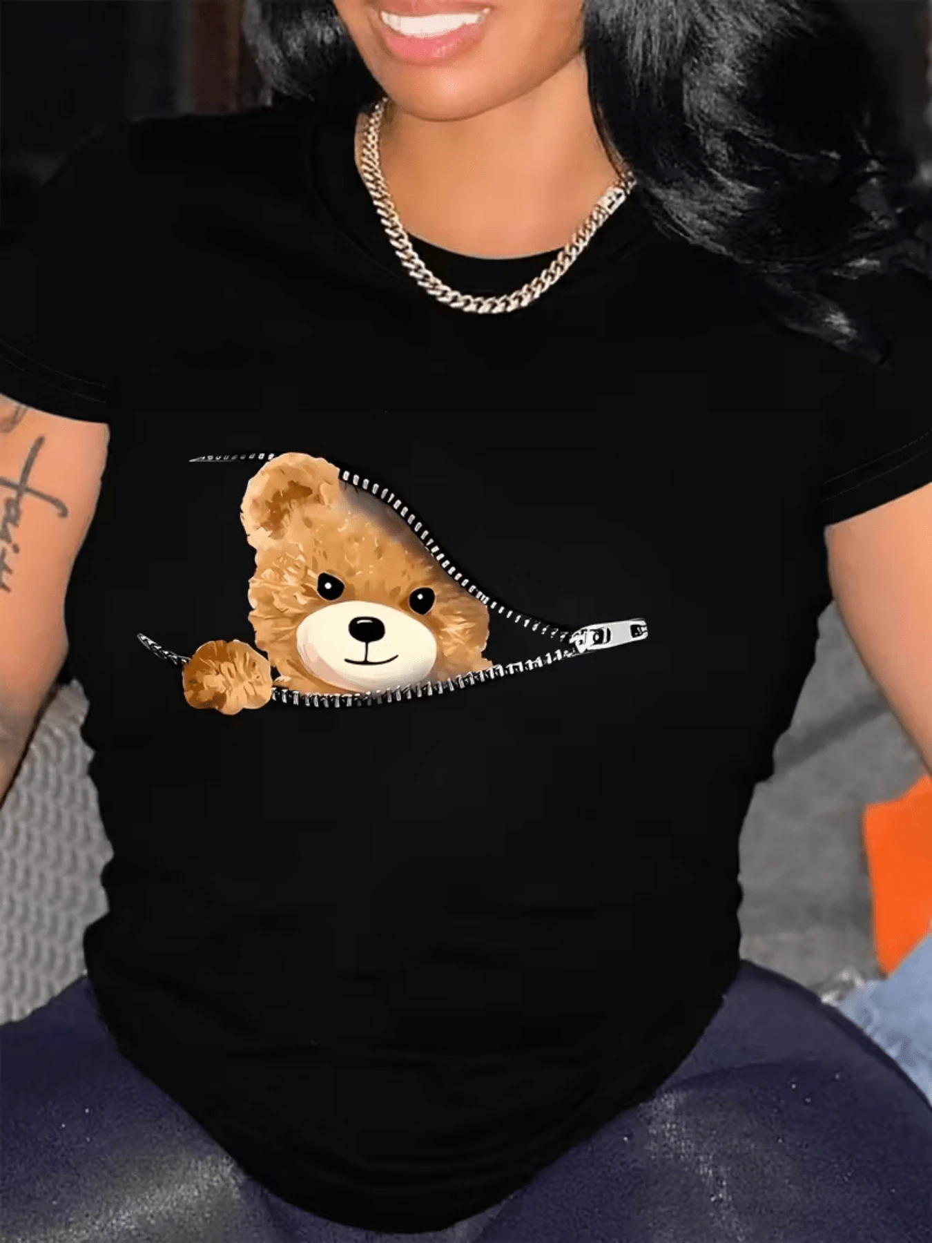 A Cute Teddy Bear Peeking Out From Behind An Open Zipper Symbolizes The Sweetness Hidden In The Feminine Heart And Conveys A Feeling Of Tenderness And Everyday Joy. A Comfortable And Modern Casual Women's T-Shirt For Everyday Wear. - 黑色 - 查看 1
