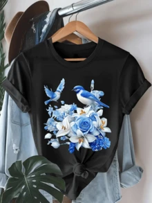 Two Blue Birds Fluttering Above A Bouquet Of Sky-Blue Roses And Lilies Symbolize Freedom, Hope, And Calm In A Harmonious Natural Setting. A Modern And Comfortable Casual Women's T-Shirt For Everyday Wear. - 黑色 - 查看 1