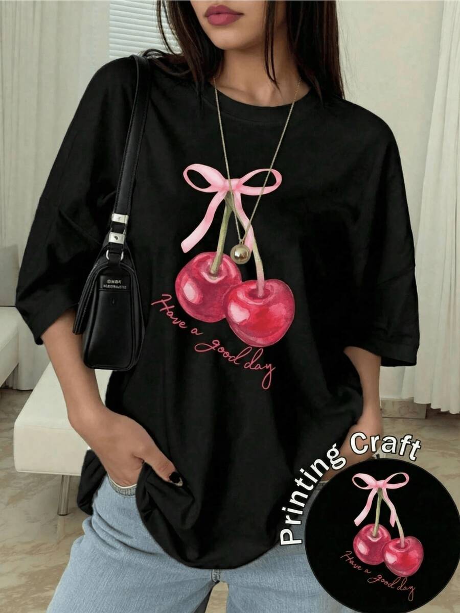 Two Bright Cherries Joined By A Pink Ribbon Convey Tenderness And Positive Energy, Inviting You To Enjoy Each Day With Joy And Confidence. A Modern, Comfortable, Casual Women's T-Shirt For Everyday Wear. - 黑色 - 查看 1