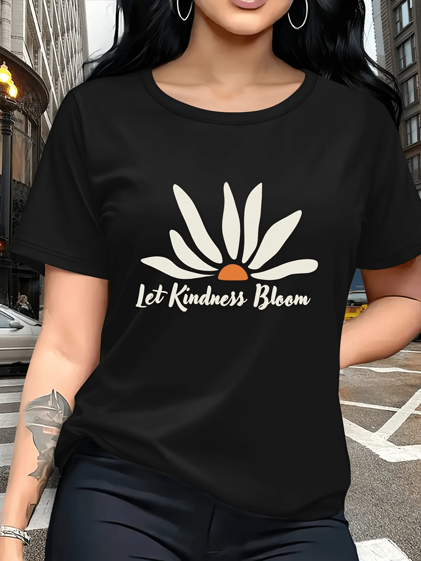 Flor con pétalos blancos y centro naranja que simboliza la amabilidad y el crecimiento interior transmitiendo un mensaje positivo y energético ideal para días relajados camiseta de mujer casual cómoda y moderna - Negro - Ver 1