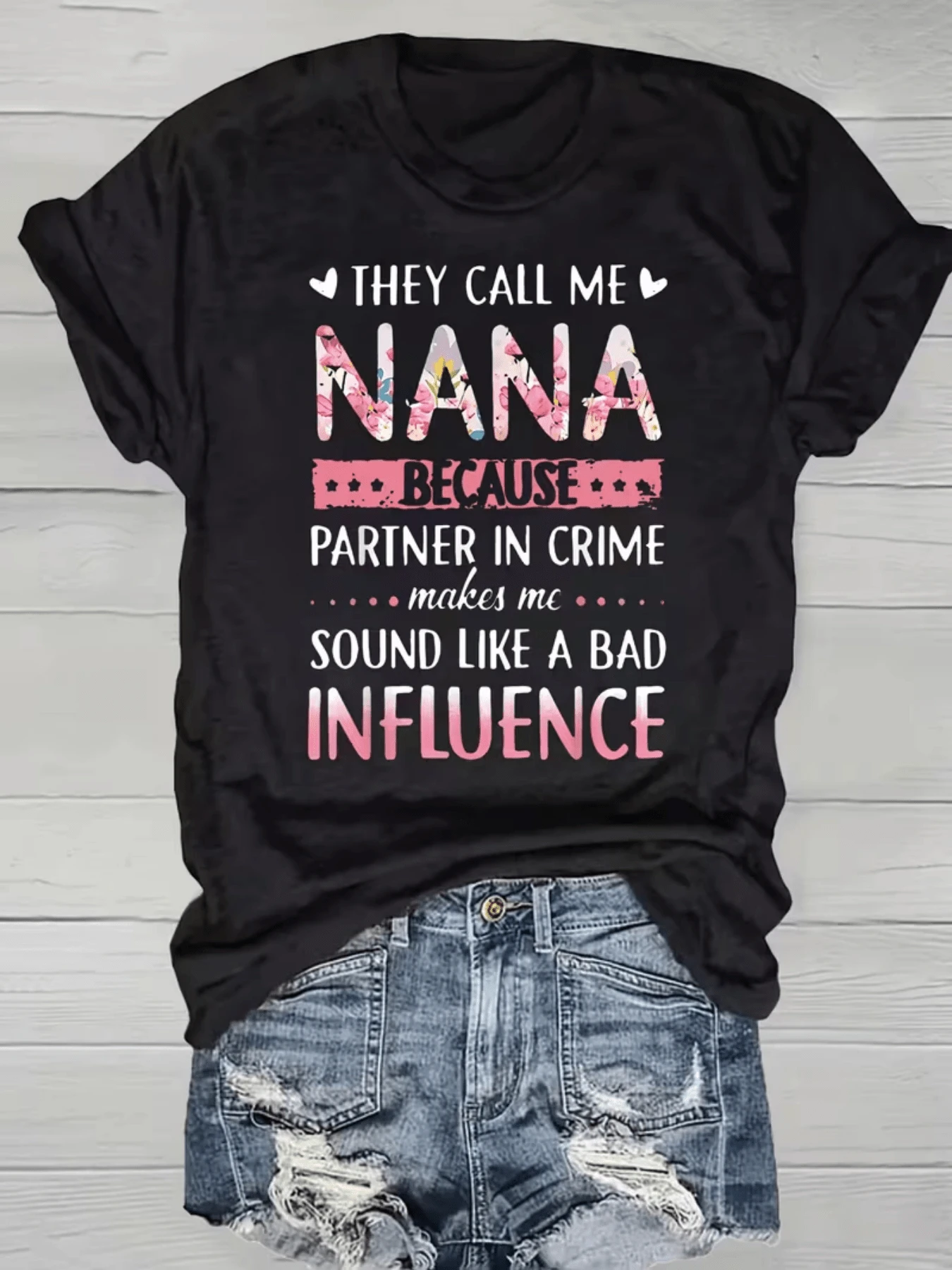 Texto divertido que transmite el orgullo y el amor de una abuela que comparte momentos únicos con sus nietos expresando humor y complicidad con frases creativas y letras floreadas que reflejan cariño y alegría camiseta de mujer casual cómoda y con mensaje positivo ideal para regalar - Negro - Ver 1