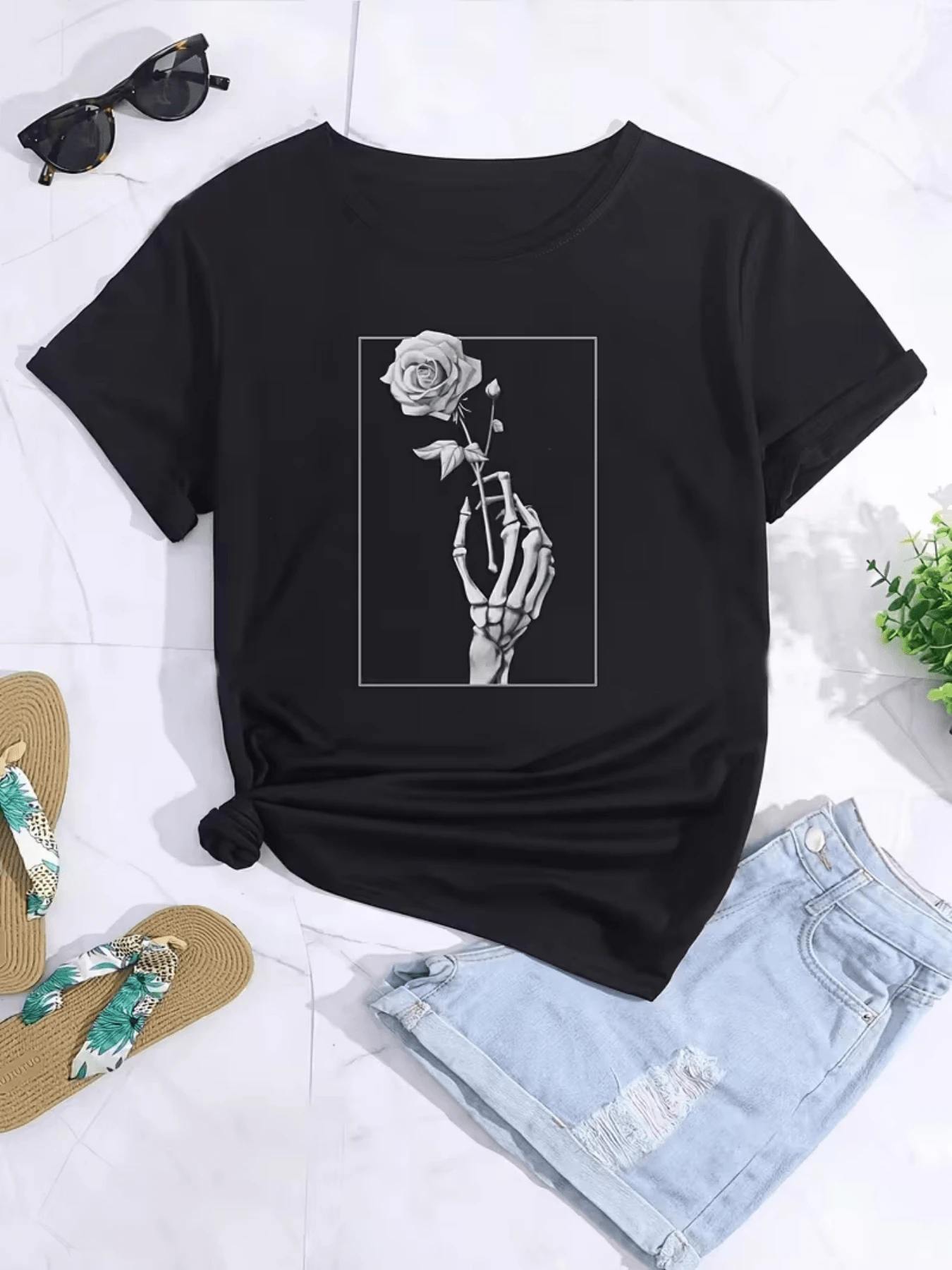 Mano esquelética sosteniendo una rosa simbolizando la unión entre la vida y la eternidad reflejando belleza y misterio camiseta de mujer casual cómoda para uso diario - Negro - Ver 1
