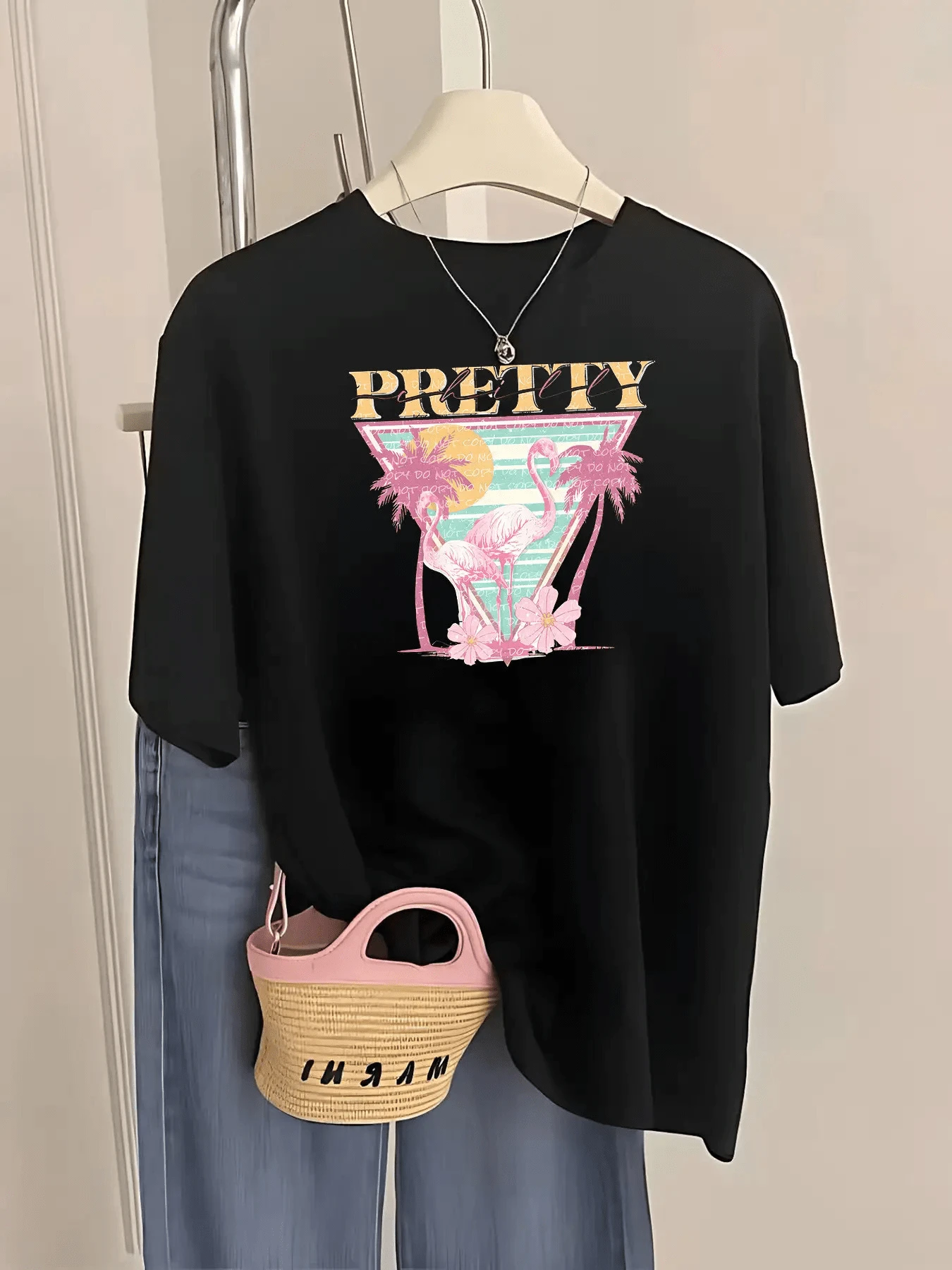 Flamencos rosados entre palmeras sobre un fondo retro con tonos turquesa y rosas evocan un atardecer tropical lleno de calma y belleza ideal para transmitir frescura y alegría camiseta de mujer moderna casual cómoda para verano - Negro - Ver 1