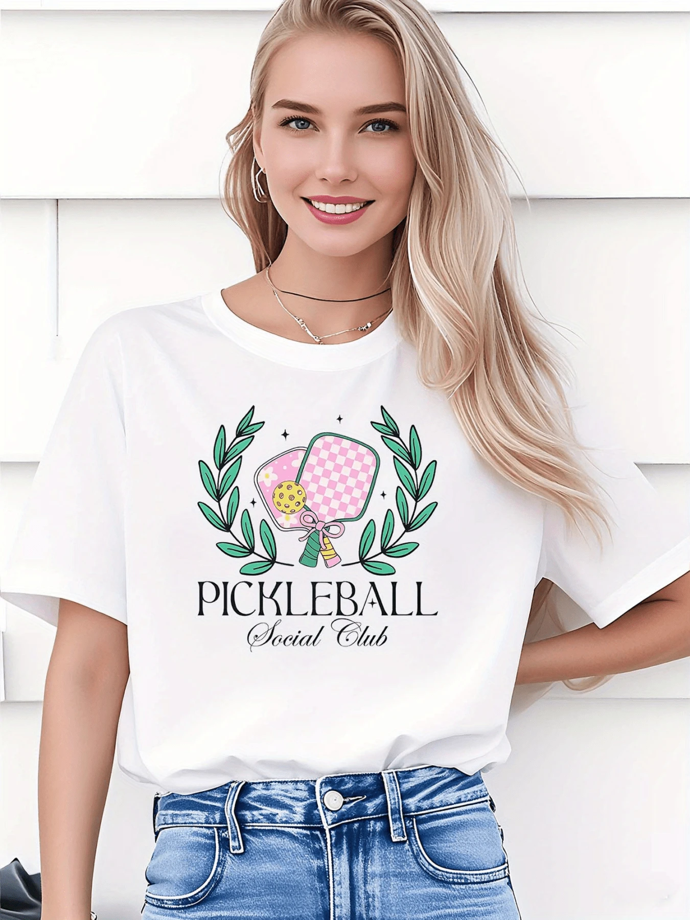 Dos palas de pickleball en tonos rosados con pelota amarilla rodeadas de hojas verdes simbolizan unión diversión y energía deportiva moderna camiseta de mujer casual perfecta para ocio y deporte urbano - Blanco - Ver 1
