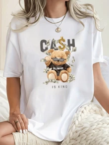 Osito con gafas rodeado de billetes y símbolo dorado de dólar representando lujo confianza y éxito con estilo divertido y moderno camiseta de mujer casual blanca cómoda y versátil para uso diario - Blanco - Ver 1