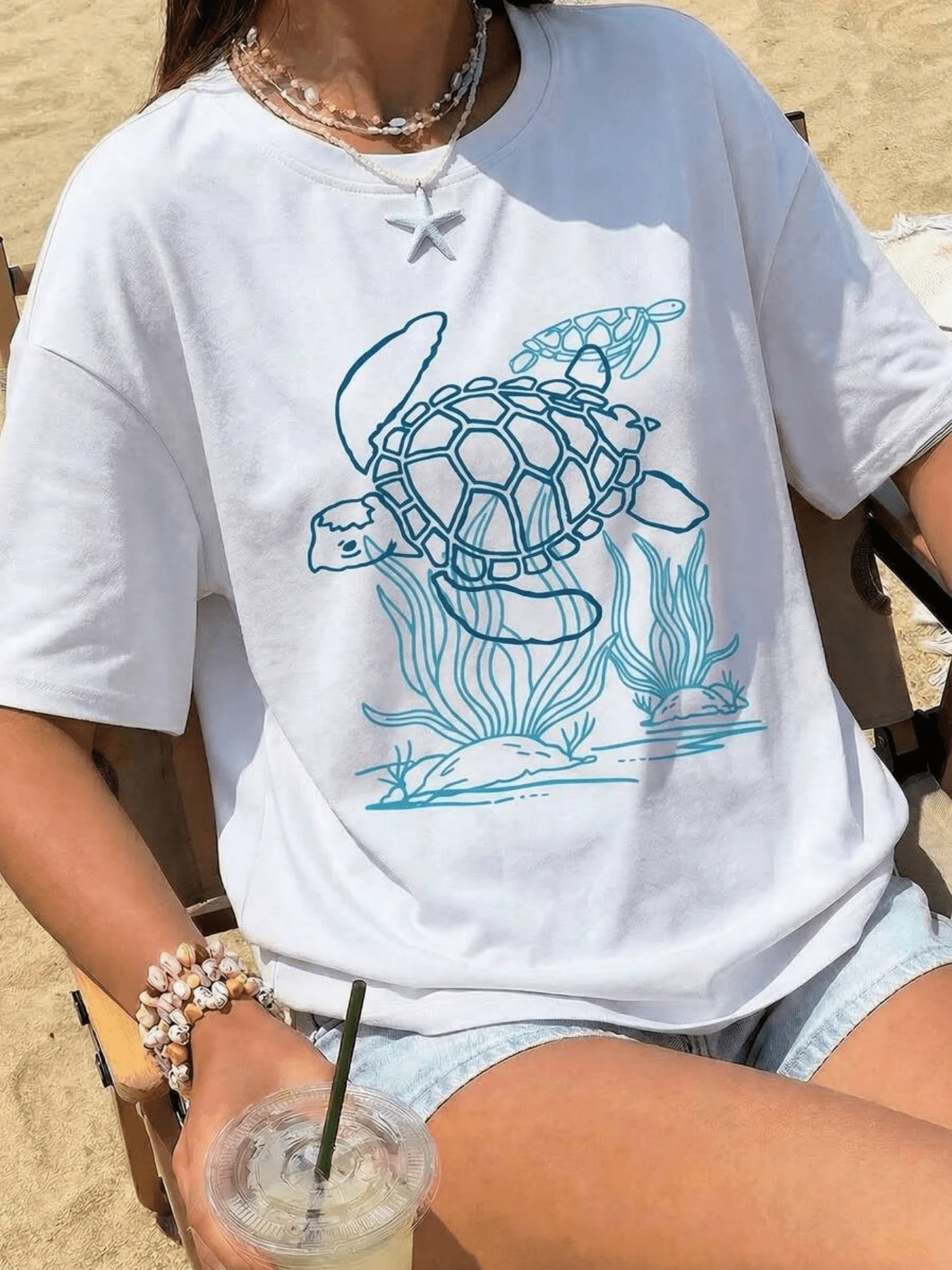 A Sea Turtle Swimming Among Coral And Seaweed Symbolizes Inner Peace And A Deep Connection With Nature, Evoking The Freedom Of The Ocean. A Comfortable, Casual Women's T-Shirt, Ideal For Summer Beach Wear. - 白色 - 查看 1