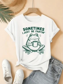 Rana sonriente sosteniendo una taza transmite un mensaje divertido sobre disfrutar los pequeños momentos con humor y serenidad camiseta de mujer casual con estampado gracioso ideal para días relajados y cómodos - Blanco - Ver 1
