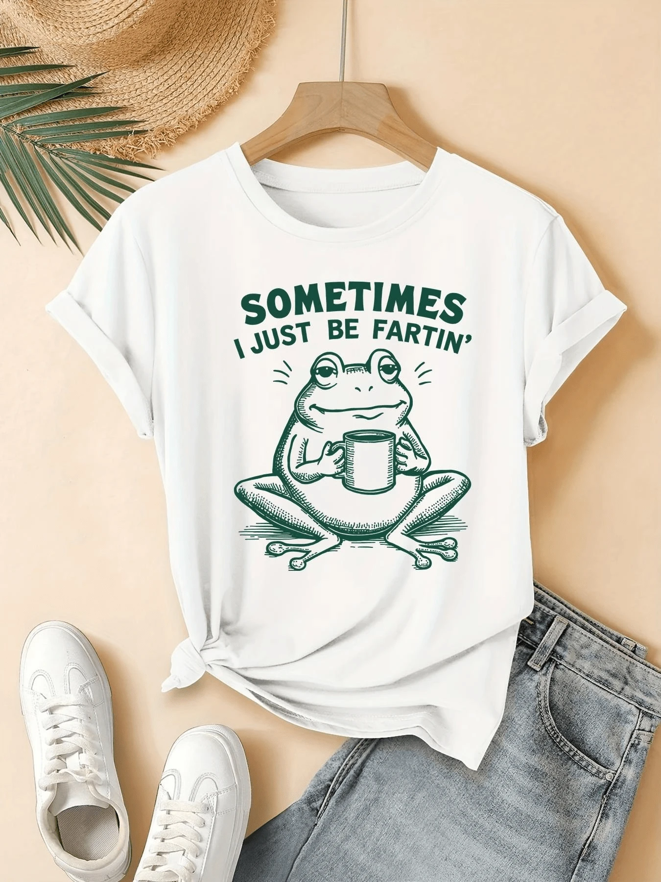 Rana sonriente sosteniendo una taza transmite un mensaje divertido sobre disfrutar los pequeños momentos con humor y serenidad camiseta de mujer casual con estampado gracioso ideal para días relajados y cómodos - Blanco - Ver 1