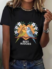 Dos periquitos coloridos sobre una rama mostrando un vínculo de amistad y ternura rodeados de flores blancas y hojas verdes dentro de un corazón cálido camiseta de mujer casual moderna ideal para uso diario - Negro - Ver 1