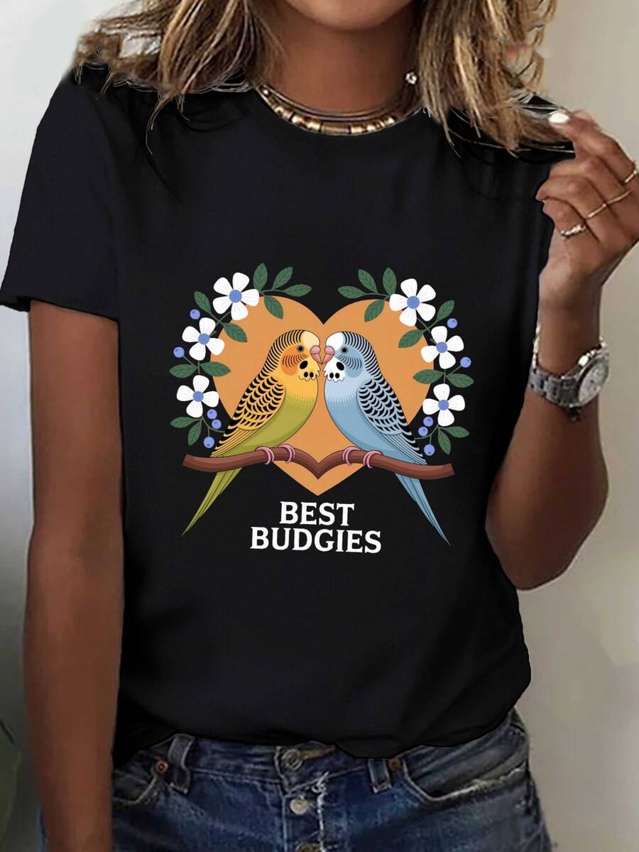 Dos periquitos coloridos sobre una rama mostrando un vínculo de amistad y ternura rodeados de flores blancas y hojas verdes dentro de un corazón cálido camiseta de mujer casual moderna ideal para uso diario - Negro - Ver 1