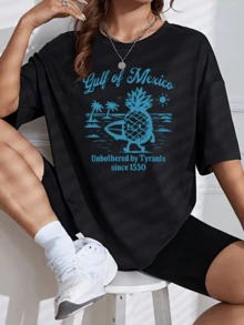 Piña sonriente con tabla de surf rodeada de palmeras bajo un sol brillante representando libertad y alegría junto al mar en el Golfo de México camiseta de mujer casual cómoda y moderna para verano - Negro - Ver 1