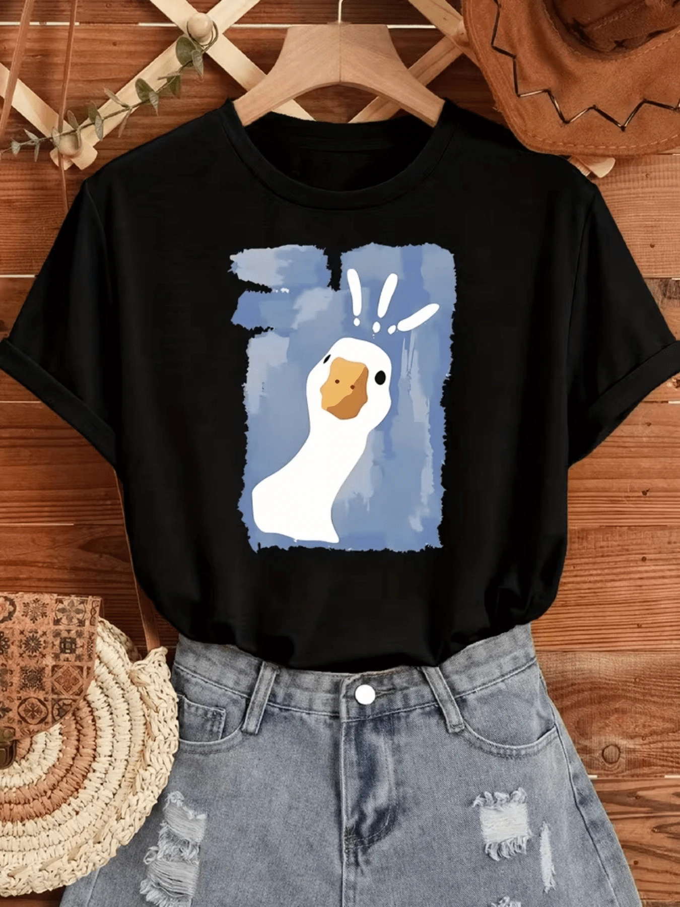 Figura de un ganso blanco con expresión curiosa sobre fondo azul simboliza la libertad y la alegría de la vida diaria camiseta de mujer casual cómoda y moderna ideal para uso urbano - Negro - Ver 1