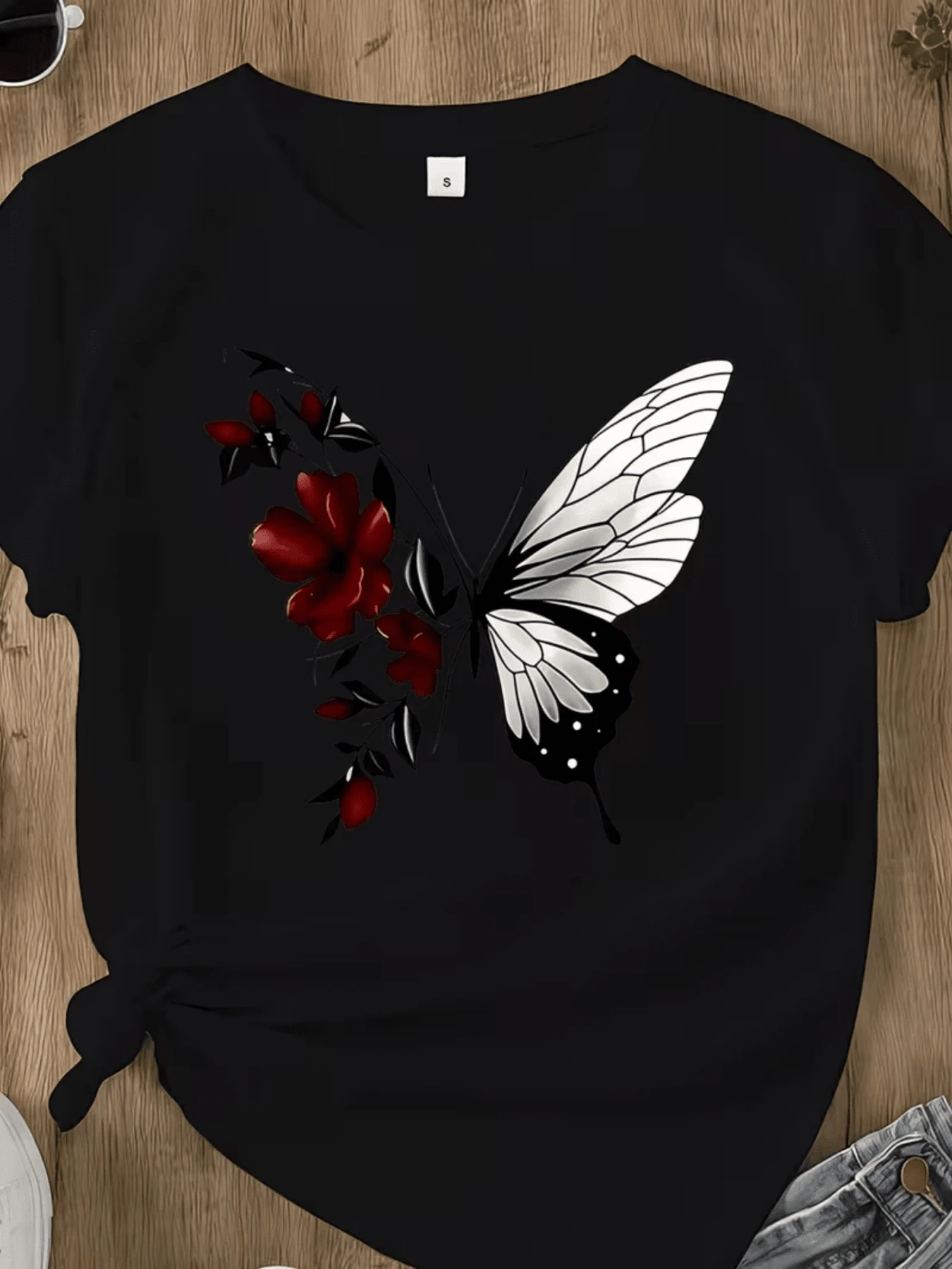 Mariposa blanca que emerge de pétalos rojos simbolizando la transformación y la fuerza interior en contraste con la oscuridad fondo elegante camiseta de mujer casual moderna - Negro - Ver 1