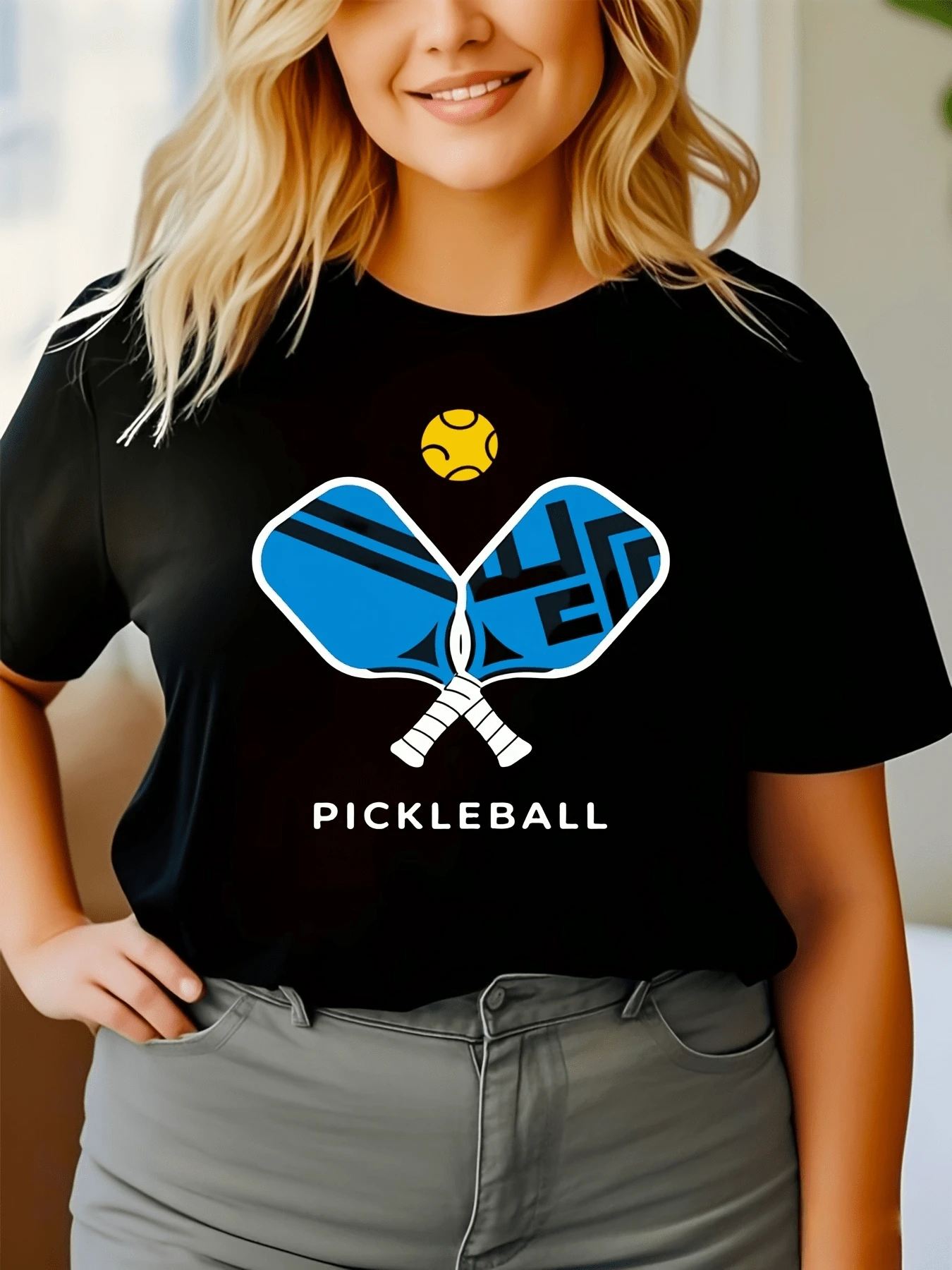 Dos palas cruzadas con formas geométricas azules y una pelota amarilla simbolizan energía movimiento y alegría deportiva camiseta de mujer cómoda para ocio y deporte - Negro - Ver 1