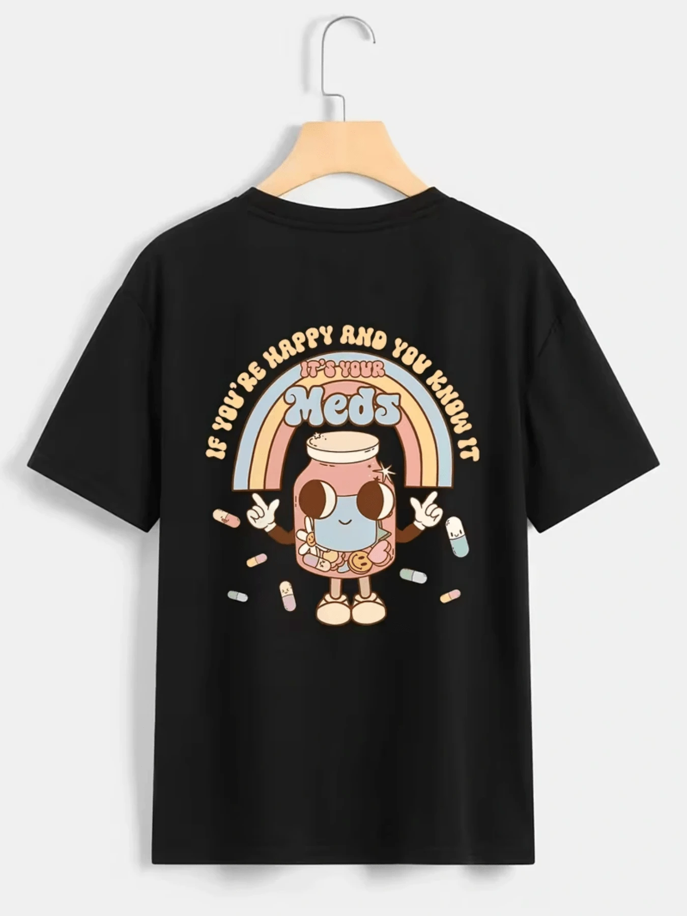 Botella adorable con rostro sonriente que irradia buen humor rodeada de píldoras de colores y un arcoíris pastel que simboliza optimismo y energía divertida camiseta de mujer casual cómoda y moderna - Negro - Ver 1