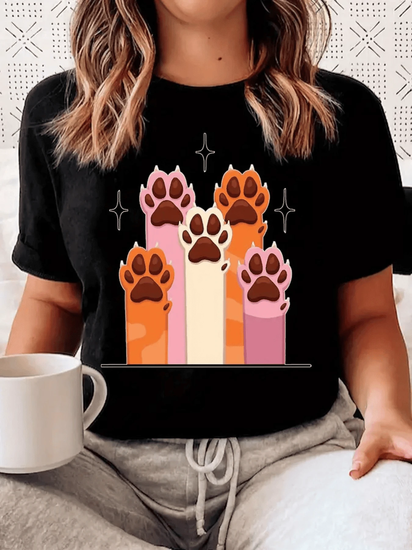 Varias huellas de gato levantadas que simbolizan ternura unión y amor por los animales en tonos cálidos y vibrantes camiseta de mujer casual cómoda y moderna para uso diario - Negro - Ver 1