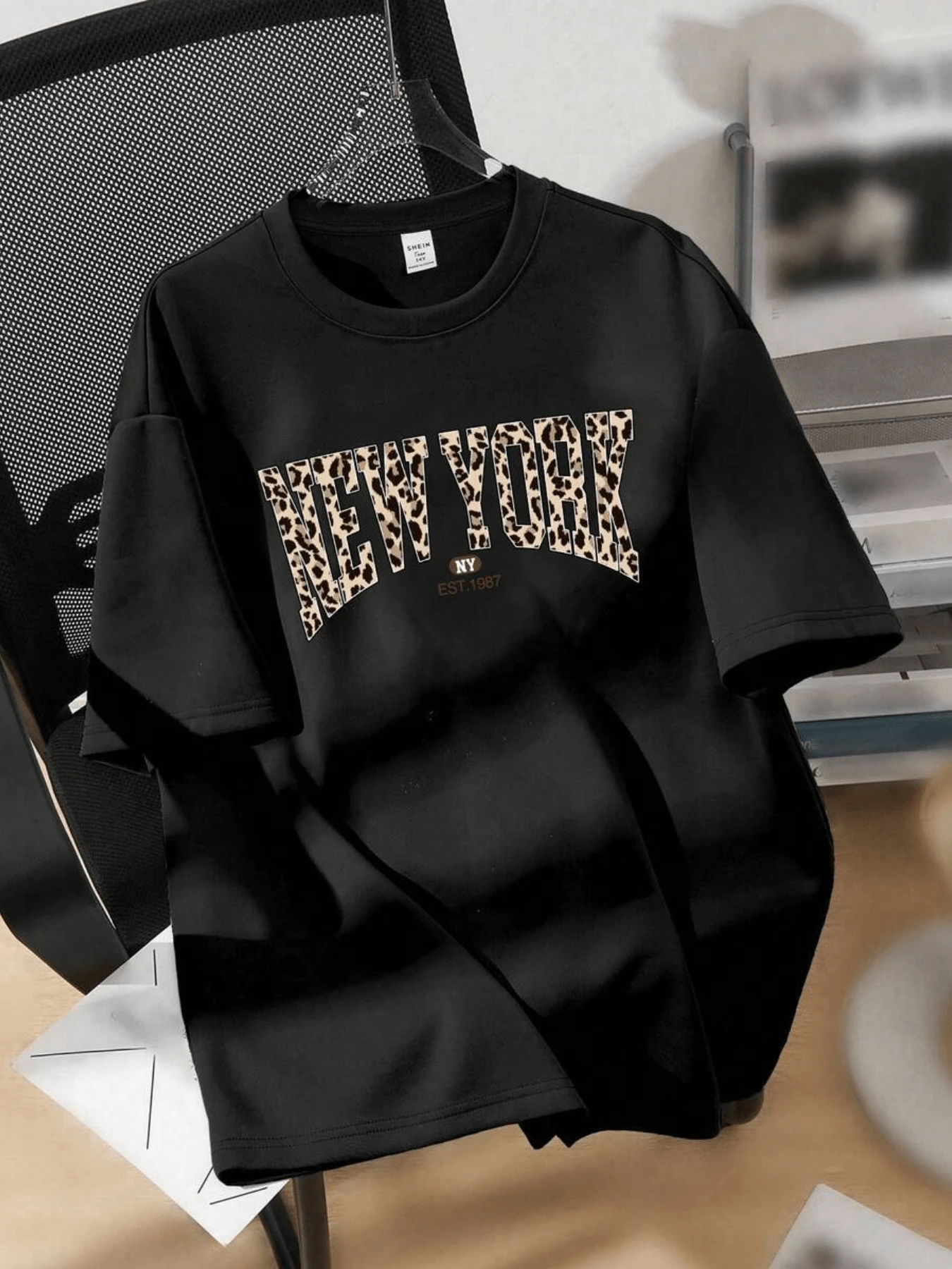Letras grandes con patrón de leopardo evocan la energía urbana y la libertad de Nueva York mostrando confianza moderna y un toque salvaje en cada detalle camiseta de mujer cómoda casual moderna - Negro - Ver 1