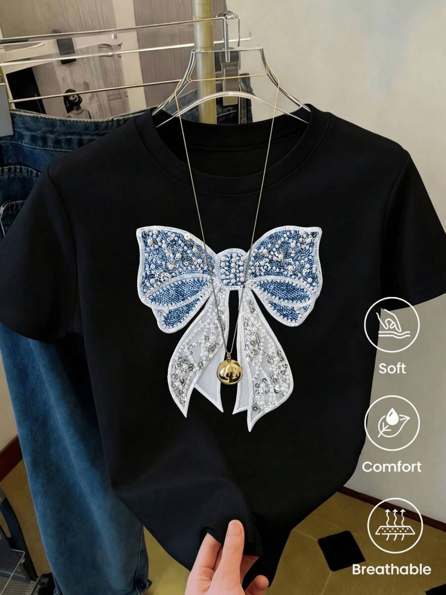 Gran lazo brillante bordado con cuentas azules y plateadas que simboliza elegancia y pureza reflejando una combinación delicada de luz y calma camiseta de mujer casual cómoda y transpirable - Negro - Ver 1