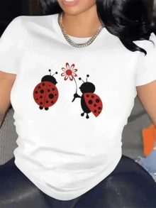 Dos mariquitas rojas simbolizan el amor y la ternura compartiendo una flor que refleja la amistad y la alegría en cada gesto camiseta de mujer cómoda moderna y alegre para uso diario - Blanco - Ver 6