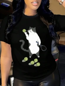 A Cat Playing With Tennis Balls Symbolizes The Curious And Joyful Energy That Drives Days Full Of Movement And Good Humor. A Comfortable, Casual Women's T-Shirt For Everyday Wear. - 黑色 - 查看 1