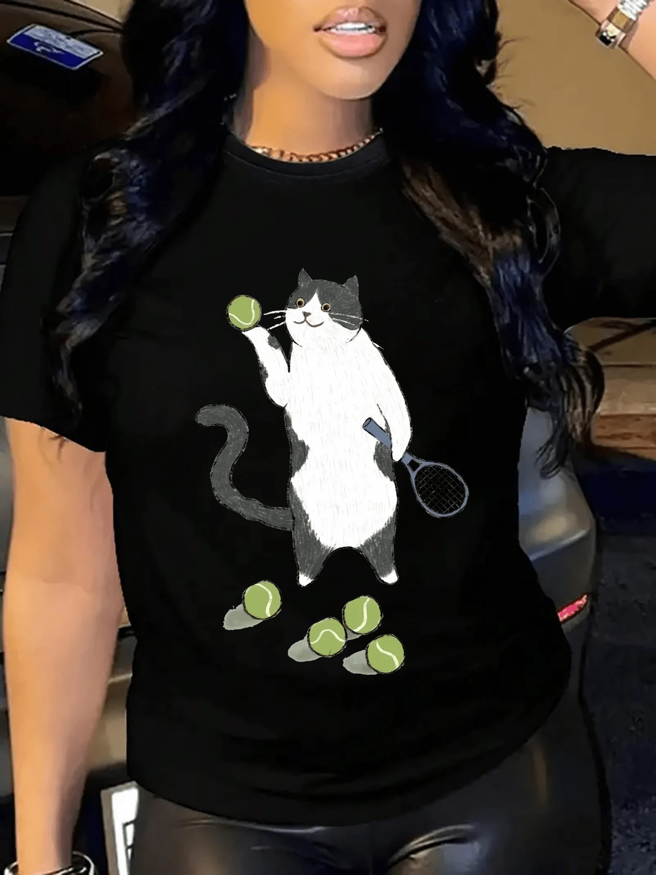 A Cat Playing With Tennis Balls Symbolizes The Curious And Joyful Energy That Drives Days Full Of Movement And Good Humor. A Comfortable, Casual Women's T-Shirt For Everyday Wear. - 黑色 - 查看 1