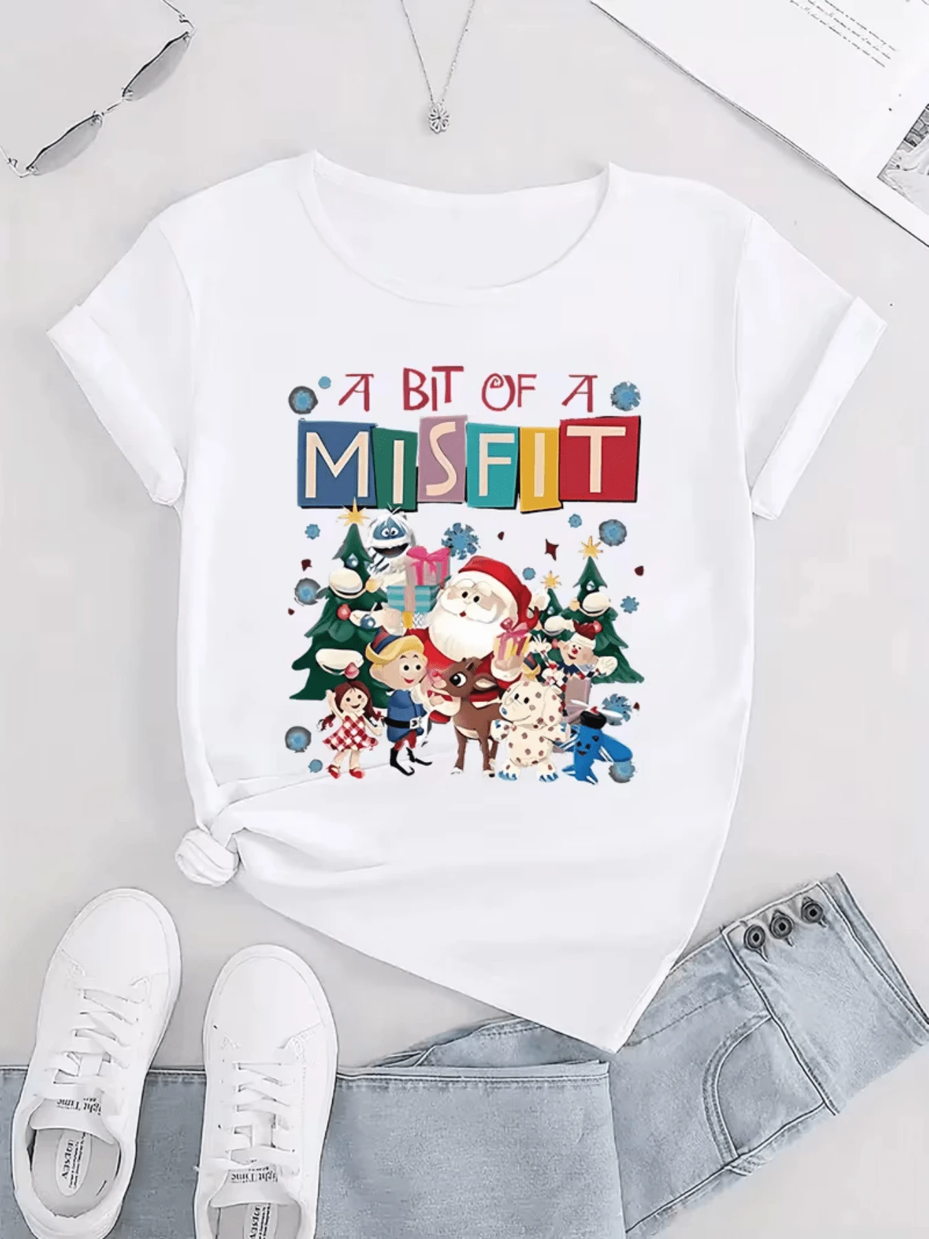Escena navideña llena de alegría con personajes felices junto a árboles decorados regalos coloridos y un ambiente festivo que transmite unión y diversión camiseta de mujer casual moderna y divertida ideal para celebraciones - Blanco - Ver 1