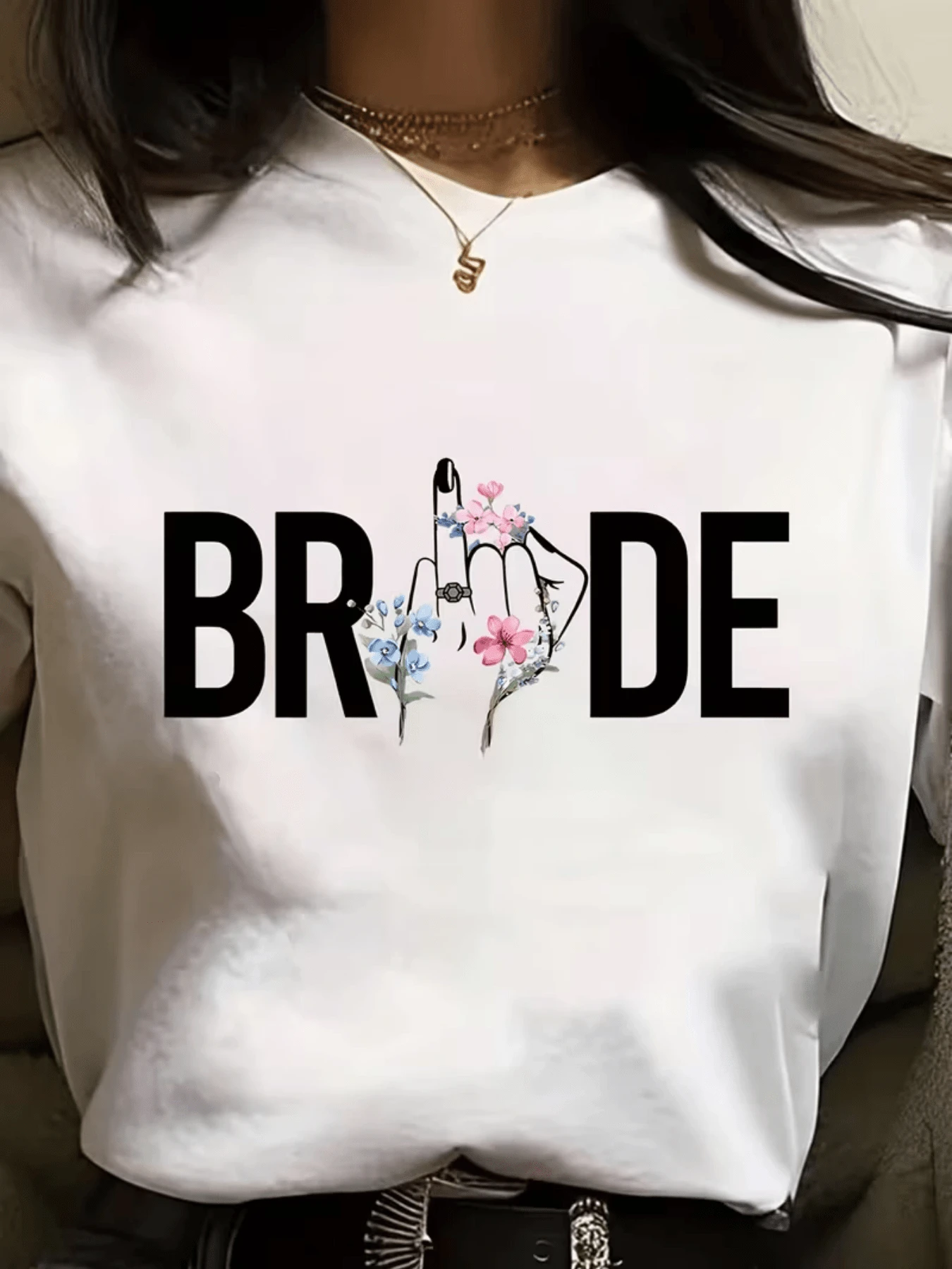 Mano femenina adornada con flores delicadas formando la palabra BRIDE representando elegancia amor y celebración para novia moderna camiseta de mujer con estampado artístico casual elegante - Blanco - Ver 1