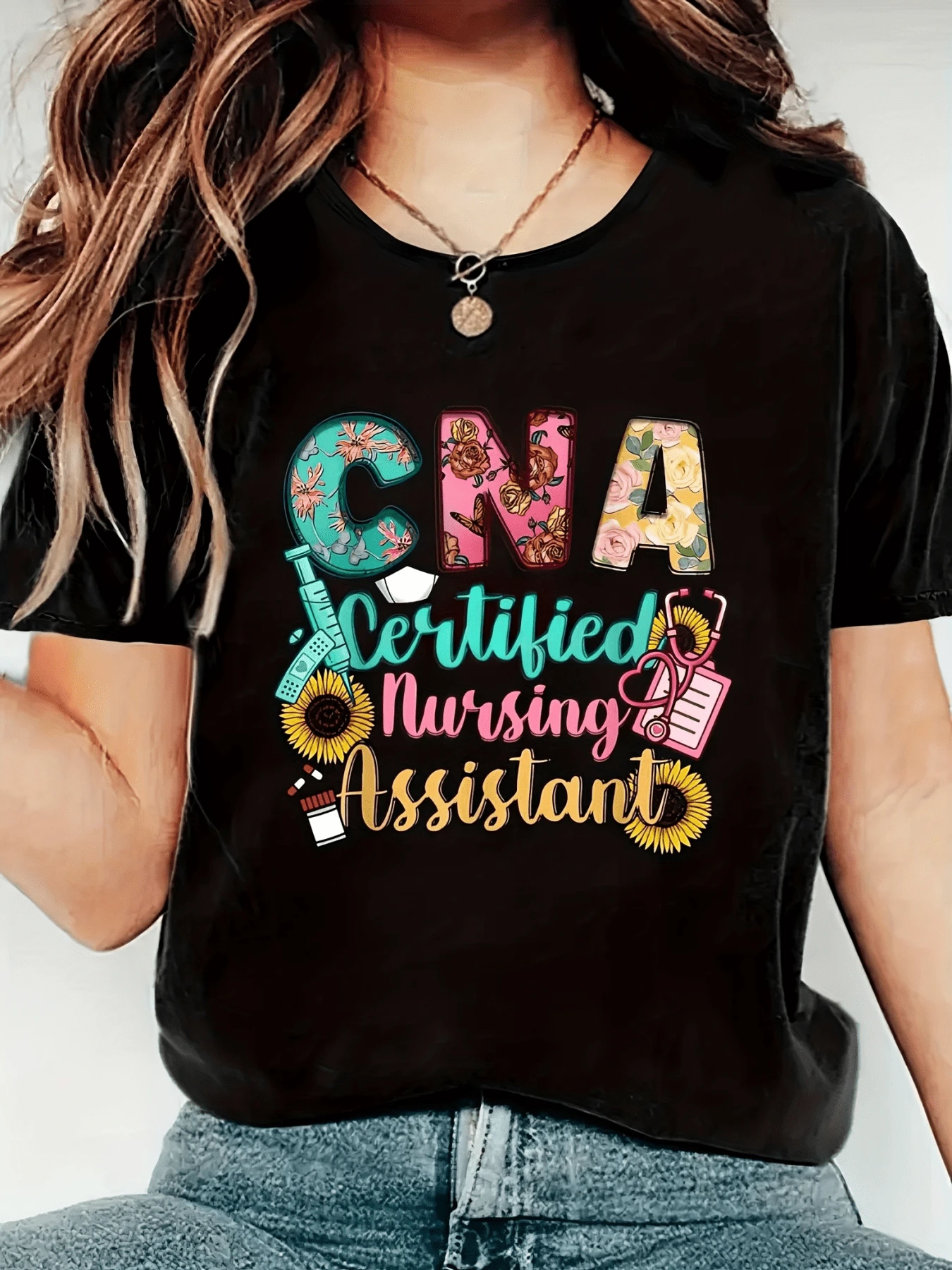 With Colorful Lettering Celebrating The Work Of Nursing Assistants, Floral Motifs (Sunflowers), And Medical Symbols Conveying Joy And Dedication, This Women's Casual, Comfortable, And Modern T-Shirt Is Perfect For Everyday Wear. - 黑色 - 查看 1