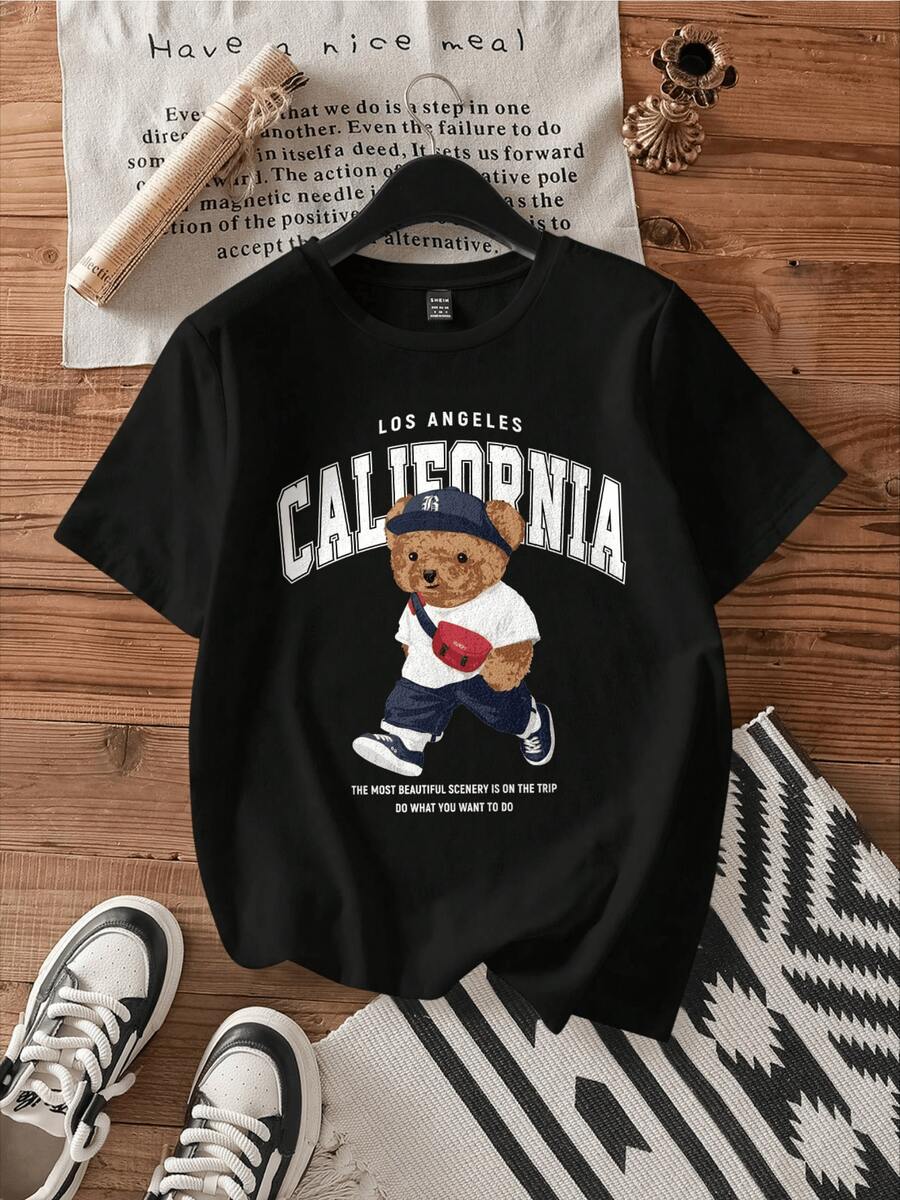 A Walking Bear Wearing A Blue Cap And Carrying A Red Bag Symbolizes A Traveler's Spirit, Freedom, And Confidence In Following Your Dreams. A Comfortable, Casual Women's T-Shirt For Everyday Wear. - 黑色 - 查看 1