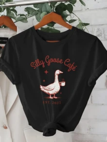 A Playful Goose Holding A Cup Of Coffee Symbolizes The Relaxed Mood Of A Peaceful Morning, Inviting You To Enjoy Warm Moments. A Comfortable, Casual Women's T-Shirt For Everyday Wear. - 黑色 - 查看 1