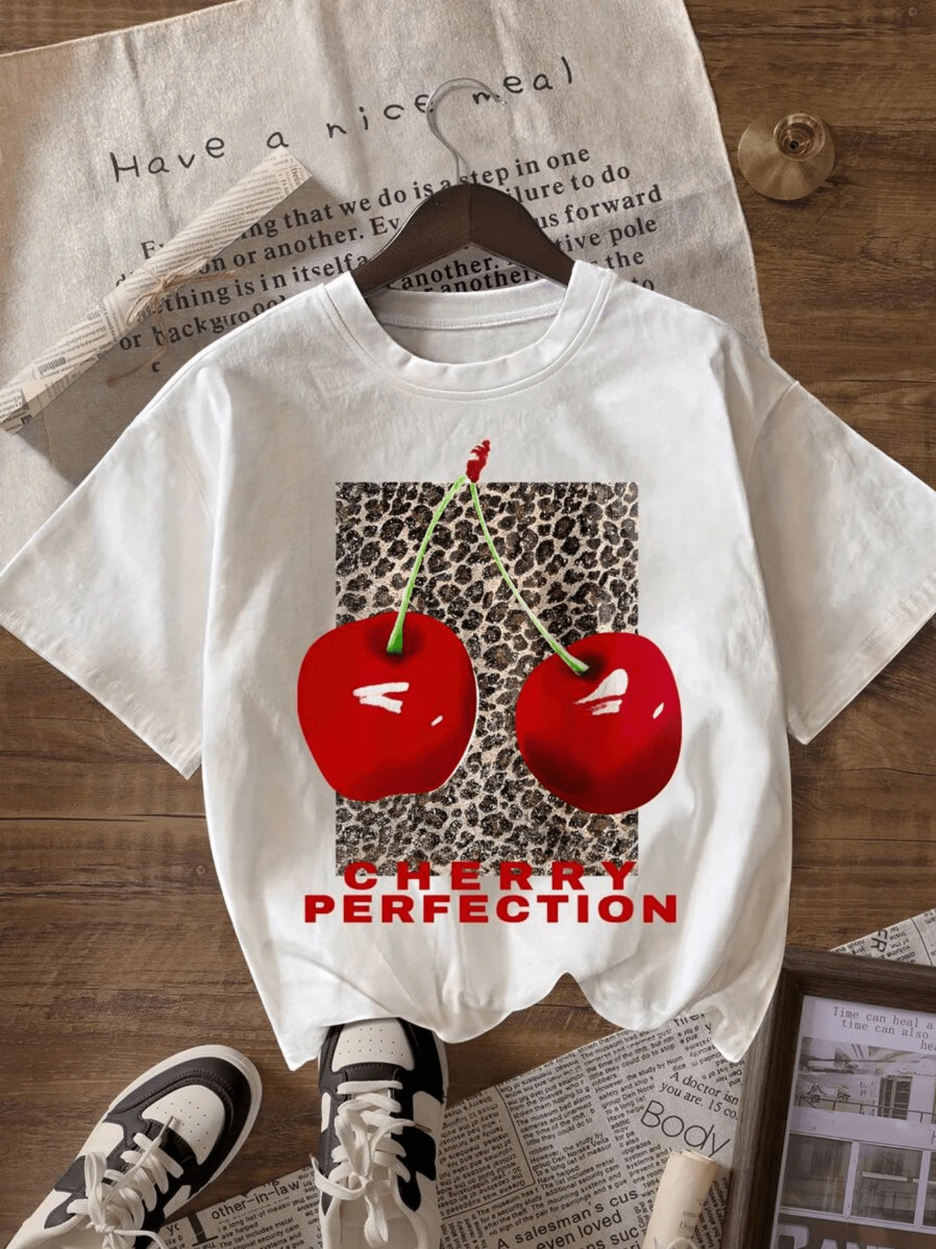Two Red Cherries, Symbols Of Energy, Passion, And Sweetness, Against An Animal Print Background Represent Modern Feminine Confidence. This Comfortable And Versatile Casual Women's T-Shirt Is Perfect For Everyday Wear. - 白色 - 查看 1