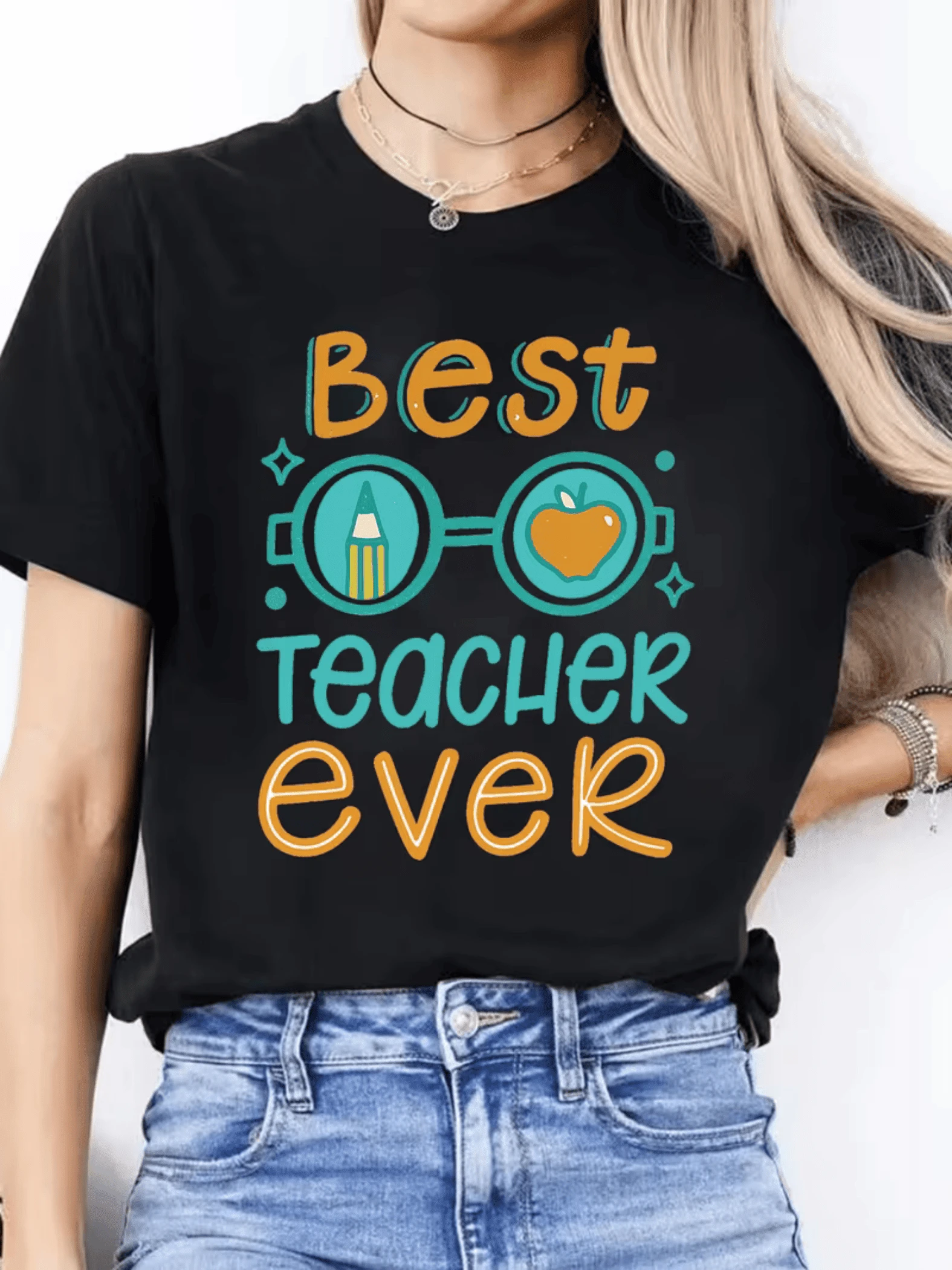 Texto colorido con letras alegres que celebran a la mejor maestra del mundo acompañado de un lápiz y una manzana símbolo de conocimiento y gratitud ideal para expresar aprecio camiseta de mujer casual cómoda para el día a día - Negro - Ver 1