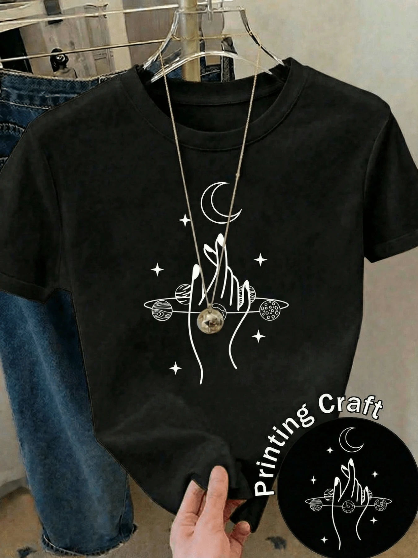 Hands Reaching Towards The Moon, Holding Planets And Stars, Symbolize The Union Between Humanity And The Cosmos, Conveying Calm And Spiritual Energy. A Modern, Casual Women's T-Shirt For Everyday Wear. - 黑色 - 查看 1